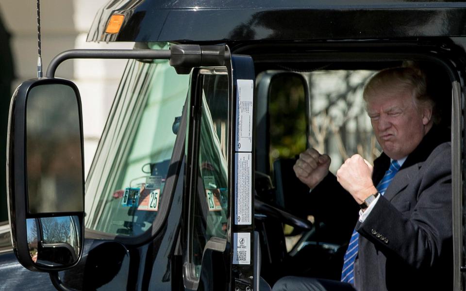 President Donald Trump gestures while sitting in an 18-wheeler truck while meeting with truckers and CEOs regarding healthcare   - Credit: AP