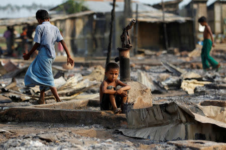 FILE PHOTO: A boy sits in a burnt area after fire destroyed shelters at a camp for internally displaced Rohingya Muslims in the western Rakhine State near Sittwe, Myanmar May 3, 2016. REUTERS/Soe Zeya Tun/File Photo