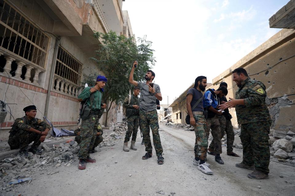 A fighter from the SDF tries to communicate on a radio amid the rubble of a damaged street in Raqqa this month Reuters: Reuters