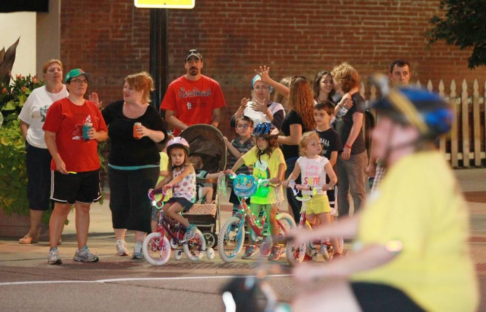 A crowd cheers on bicyclists from the corner of Church and East Main streets.