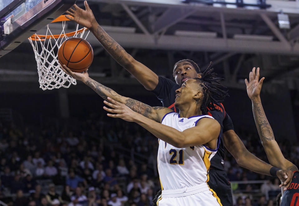 East Carolina's Jaden Walker (21) shoots against Houston's Ja'Vier Francis, rear, during the second half of an NCAA college basketball game in Greenville, N.C., Saturday, Feb. 25, 2023. (AP Photo/Ben McKeown)