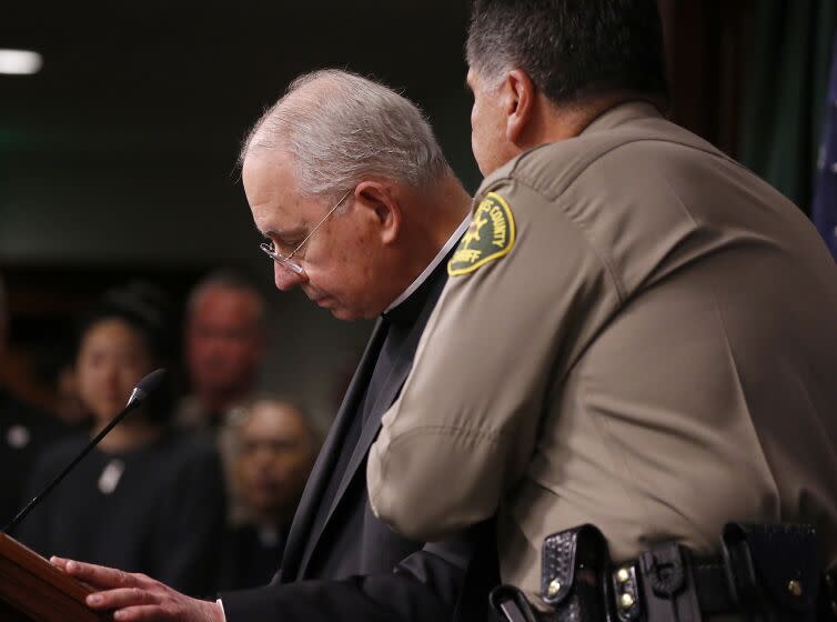 LOS ANGELES, CALIF. - FEB. 20, 2023. Sheriff Robert Luna comforts L.A. Archbishop Jose Gomez during a press conference in downtown Los Angeles on Monday, Feb. 20, 2023, to announce the arrest of a suspect in the murder of Roman Catholic Bishop David O'Connell. Authorities took 65-year-old Carlos Medina into custody early Sunday morning. He is the husband of the housekeeper where O'Connell lived. (Luis Sinco / Los Angeles Times)