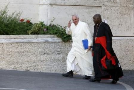 Pope Francis arrives to lead the synod on the family in the Synod hall as he is flanked by Cardinal Philippe Nakellentuba Ouedraogo (R) at the Vatican, October 23, 2015. REUTERS/Alessandro Bianchi