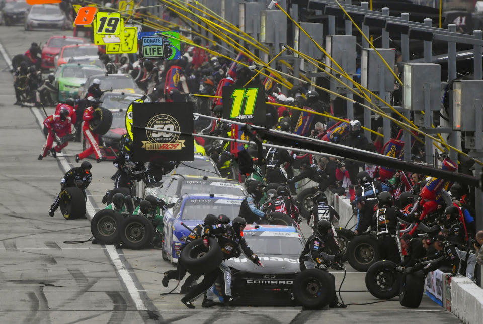 Crew members tend to Tyler Reddick's car in front as others pits stop along with him during a NASCAR Xfinity auto race at Atlanta Motor Speedway, Saturday, Feb. 23, 2019, in Hampton, Ga. (AP Photo/John Amis)