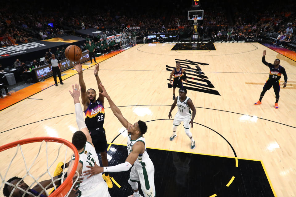 Phoenix Suns forward Mikal Bridges (25) shoots as Milwaukee Bucks' Giannis Antetokounmpo (34) and Brook Lopez (11) defend during Game 2 of basketball's NBA Finals, Thursday, July 8, 2021, in Phoenix. (Mark J. Rebilas/Pool Photo via AP)