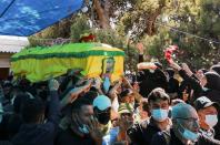 Women throw rose petals at the coffin of Mohamed Tahan, who was killed at the border fence with Israel yesterday, during his funeral in Adloun