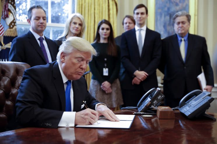 President Trump signs an executive order as his top advisers, including Steve Bannon, look on. (Photo: Shawn Thew-Pool/Getty Images)