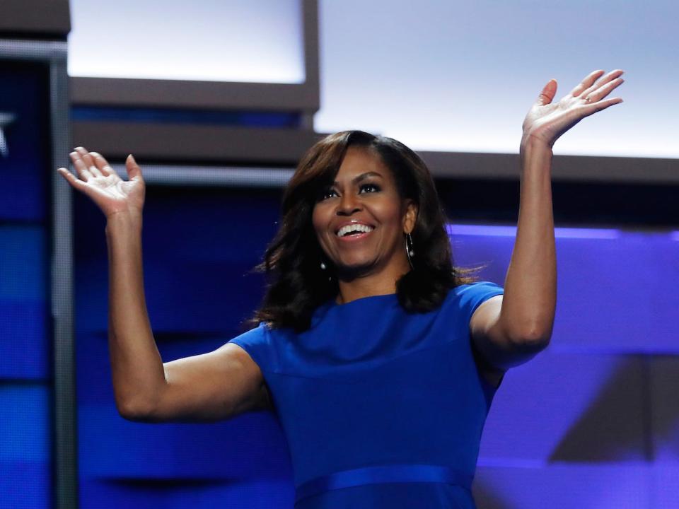 Michelle Obama speaks at an event wearing a blue dress