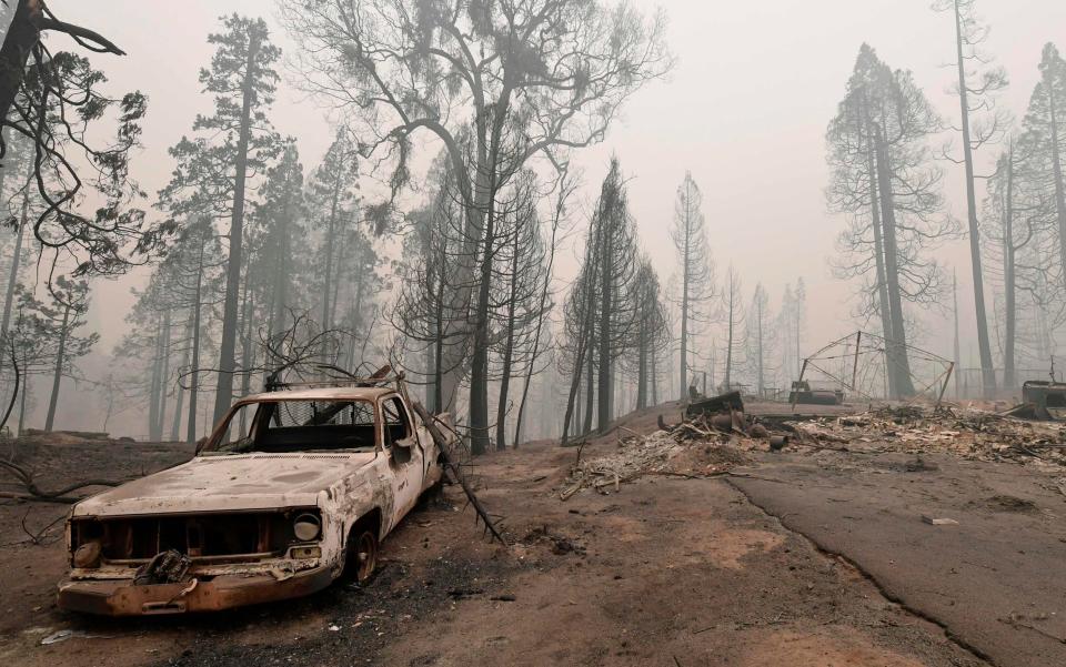 A burnt vehicle is pictured beside a fire-ravaged home during the Creek fire in Auberry, Fresno County, California - FREDERIC J. BROWN /AFP