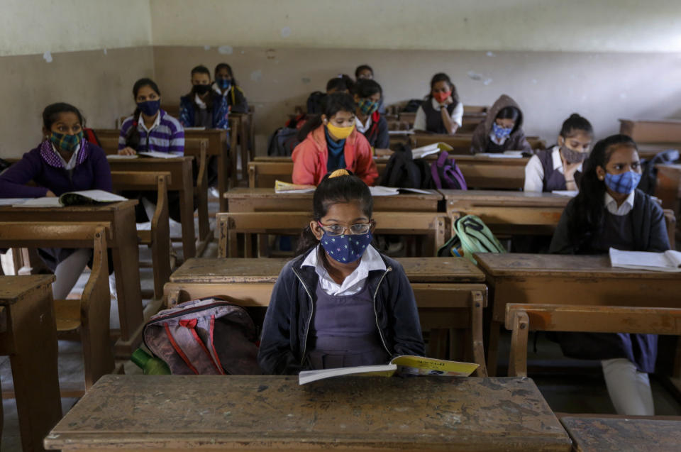 Students wearing face masks as a precaution against the coronavirus, attend classes as schools reopen after being closed for months due to the COVID-19 pandemic in Ahmedabad, India, Monday, Jan. 11, 2021. The Gujarat state has reopened schools only for classes 10 and 12. (AP Photo/Ajit Solanki)