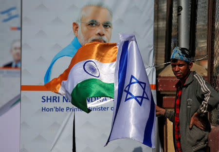 A man holds flags of India and Israel before installing them on a lamp post ahead of the visit of Israeli Prime Minister Benjamin Netanyahu in Ahmedabad, India January 15, 2018. REUTERS/Amit Dave