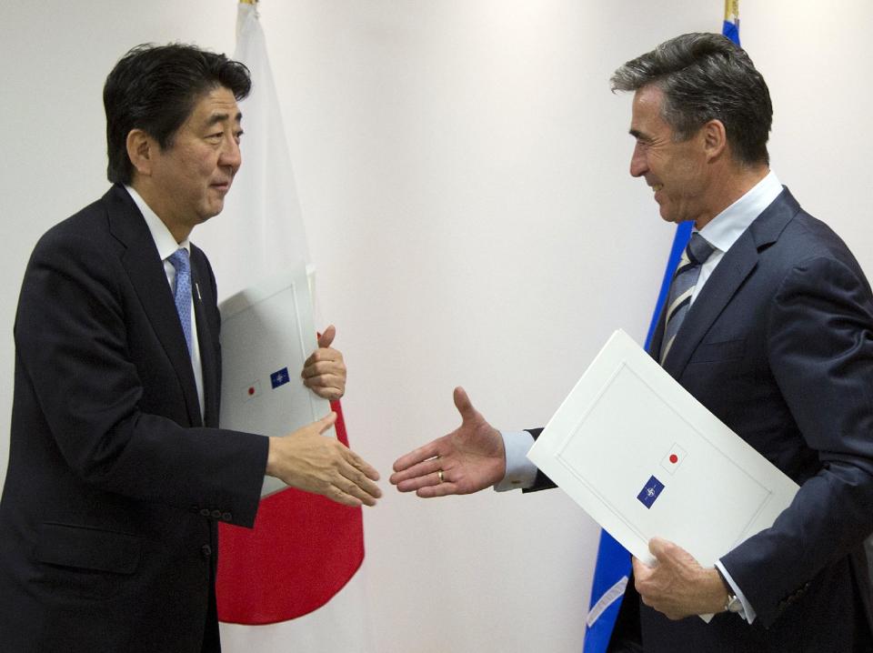 Japan's Prime Minister Shinzo Abe, left, and NATO Secretary General Anders Fogh Rasmussen shake hands after signing a cooperation agreement at NATO headquarters in Brussels on Tuesday, May 6, 2014. Abe will, in a two-day visit, meet with NATO, EU and Belgian officials. (AP Photo/Virginia Mayo, Pool)