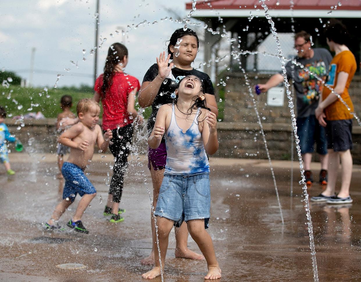 Ava Rodriguez, 8, of Springfield, front, cools off with her cousin Jaylait Flores, 9, of Berwyn at the splash pad at Southwind Park Saturday June 11, 2022.