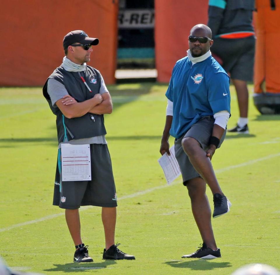 Miami Dolphins defensive coordinator Josh Boyer talks with coach Brian Flores during training camp practice Tuesday.