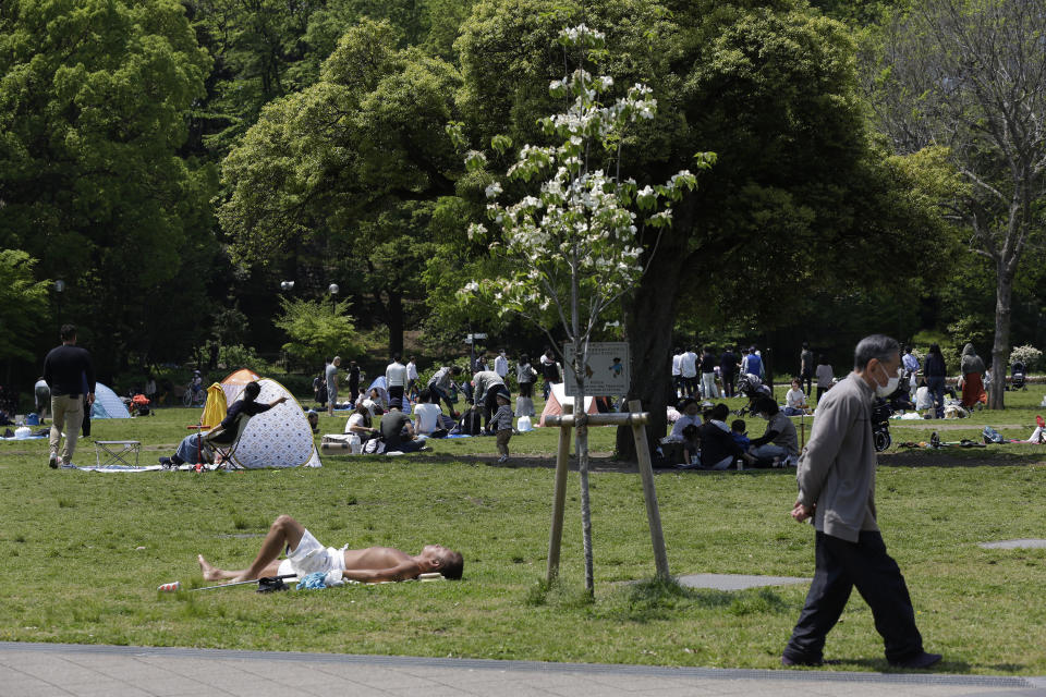 In this April 29, 2020 photo, Shiba Park is packed with families with small children day camping in tents on the first day of the "Golden Week" holidays in Tokyo. Under Japan's coronavirus state of emergency, people have been asked to stay home. Many are not. Some still have to commute to their jobs despite risks of infection, while others are dining out, picnicking in parks and crowding into grocery stores with scant regard for social distancing. (AP Photo/Kiichiro Sato)