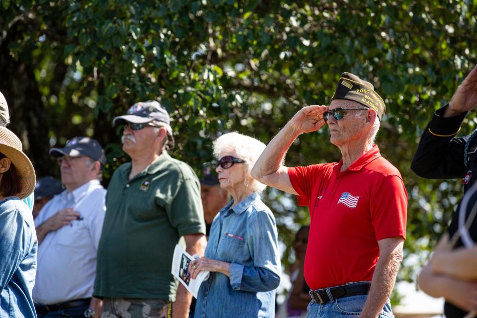 Veterans and guests attending the Gadsden-Etowah Patriots Association's annual Memorial Day commemoration on Monday, May 30, 2022, at Ola Lee Mize Patriots Park salute and stand during the Pledge of Allegiance.