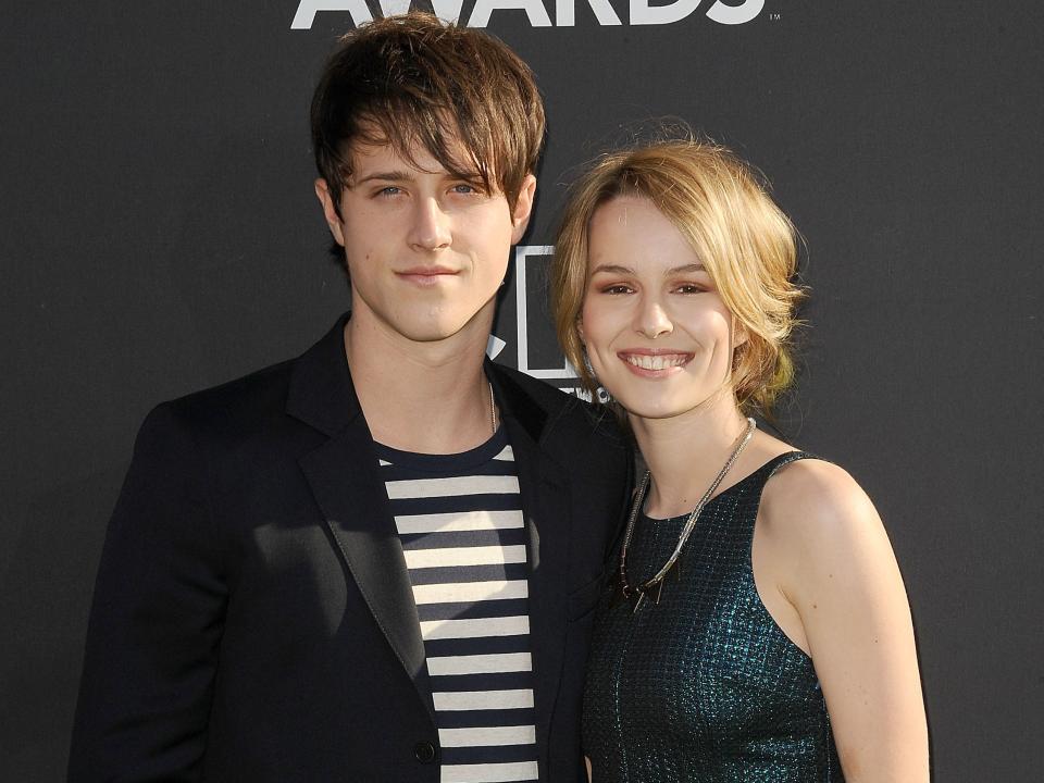 Shane Harper and Bridgit Mendler with their arms around each other.