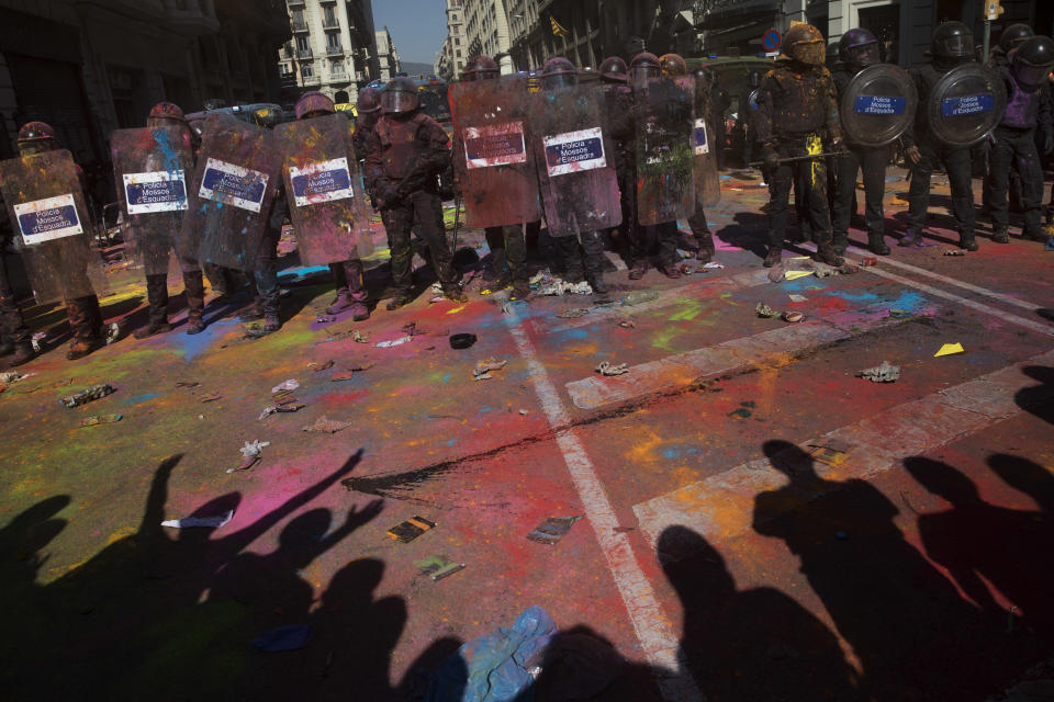 Catalan police officers cordon off the street to stop pro independence demonstrators on their way to meet demonstrations by members and supporters of National Police and Guardia Civil, as coloured powder is seen on the ground after being thrown by protesters, in Barcelona on Saturday, Sept. 29, 2018. (AP Photo/Emilio Morenatti)
