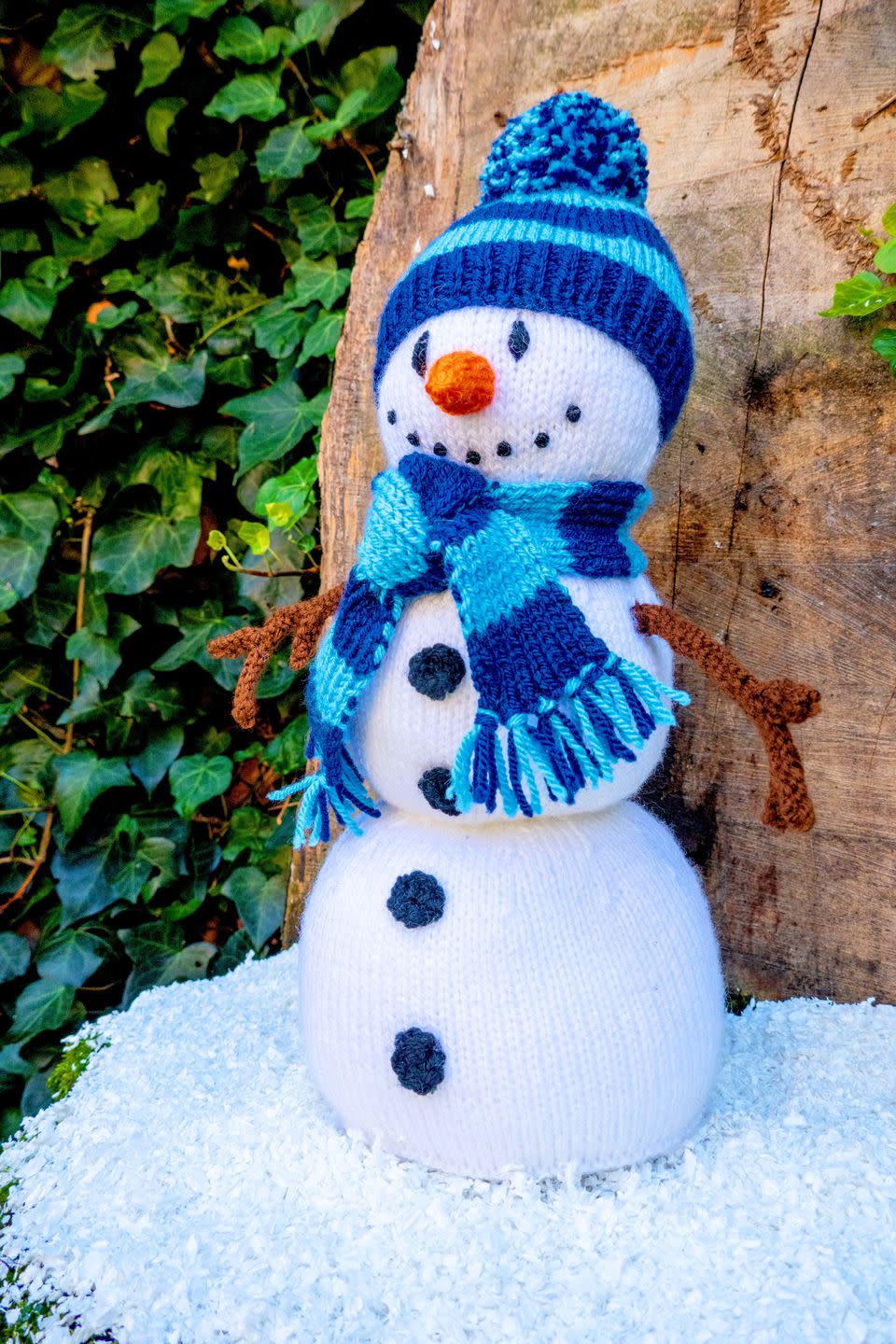 a knitted snowman with a blue scarf