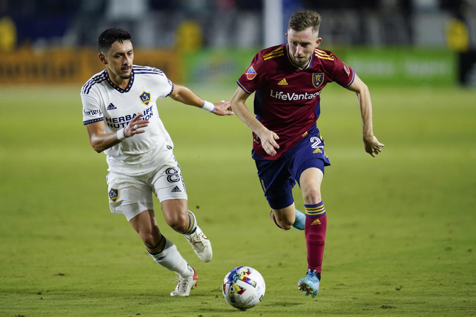 LA Galaxy midfielder Marco Delgado (8) and Real Salt Lake defender Andrew Brody (2) run toward the ball during the second half of an MLS soccer match in Carson, Calif., Saturday, Oct. 1, 2022. (AP Photo/Ashley Landis)