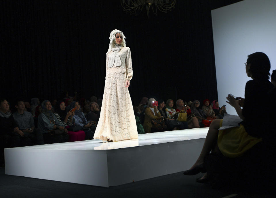 In this Saturday, May 31, 2013 photo, a model showcases a creation by Indonesian designer Irna Mutiara during the Islamic Fashion Fair in Jakarta, Indonesia. The event is part of the Indonesian government's effort to turn the most populous Muslim country into the world's Islamic fashion capital by 2020. (AP Photo/Dita Alangkara)