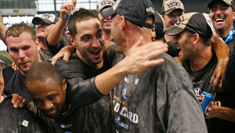 Ryan Braun, center, gives manager Dale Sveum a hug among champagne soaked players during celebration after their win Sunday at Miller Park over the Chicago Cubs.