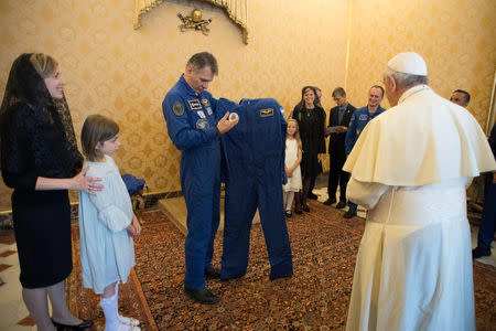 Pope Francis receives an astronaut suit from Italian astronaut Paolo Nespoli during a private meeting with crew members of the ISS 53 space mission at the Vatican June 8, 2018. Vatican Media/Handout via REUTERS