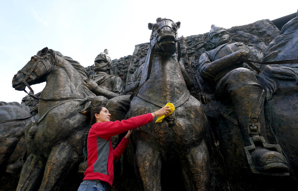 <p>Gabriella Diment prepares a monumental bronze patinated fibreglass wall sculpture depicting household cavalry soldiers on horseback which is expected to be sold for �12,000-18,000 when it goes up for auction at Summers Place Auctions in Billinghurst, Kent. Picture date: Tuesday September 21, 2021.</p>
