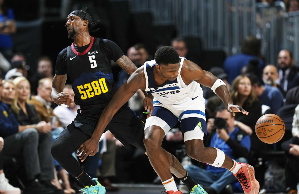 Minnesota Timberwolves guard Anthony Edwards, right, collects the ball while fending off Denver Nuggets guard Kentavious Caldwell-Pope during the first half of Game 5 of an NBA basketball second-round playoff series Tuesday, May 14, 2024, in Denver (AP Photo/David Zalubowski)