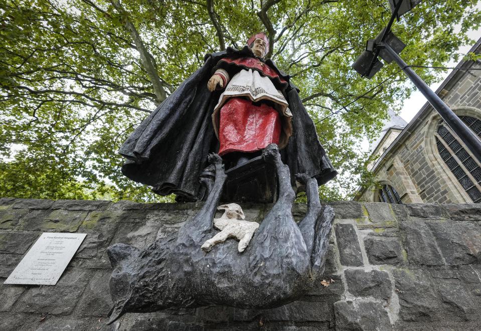 The monument of German cardinal Franz Hengsbach with a lamb sitting on a wolf is seen beside the cathedral in the city center of Essen, western Germany, Friday, Sept. 22, 2023. The Catholic Church is investigating allegations of sexual abuse by the late cardinal over 30 years after his death. (AP Photo/Martin Meissner)