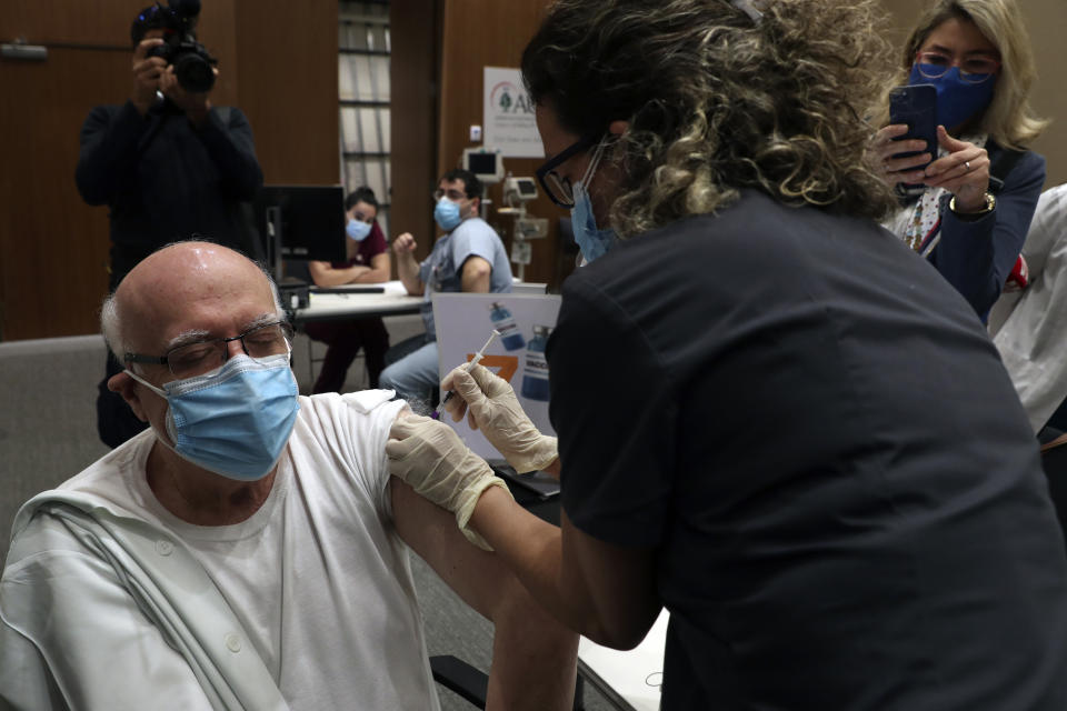 A healthcare worker receives Pfizer-BioNTech COVID-19 vaccine during a nationwide vaccination program at the American University Medical Center in Beirut, Lebanon, Sunday, Feb. 14, 2021. (AP Photo/Bilal Hussein)