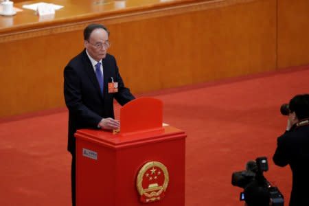 Wang Qishan, former secretary of the Central Commission for Discipline Inspection, drops his ballot during a vote at the fifth plenary session of the National People's Congress (NPC) at the Great Hall of the People in Beijing, China March 17, 2018.  REUTERS/Jason Lee