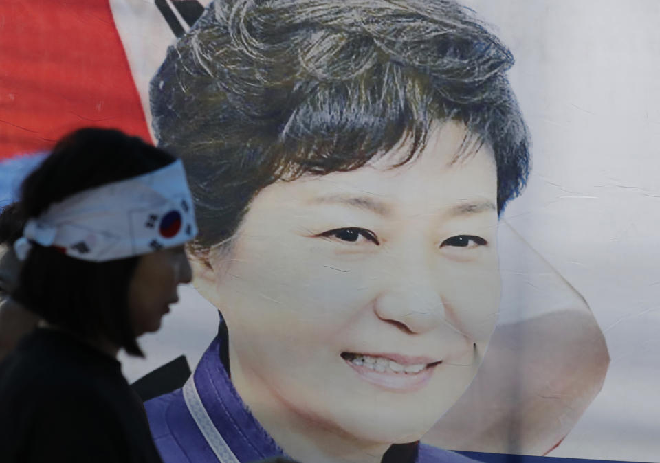 FILE - In this Aug. 29, 2019, file photo, a supporter of former South Korean President Park Geun-hye walks by the banner with her picture near the Supreme Court of Korea in Seoul, South Korea. South Korea’s top court upheld 20-year prison term for Park over corruption on Thursday, Jan. 14, 2021. (AP Photo/Lee Jin-man, File)