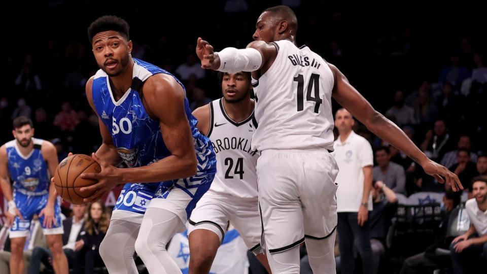 Maccabi Ra'anana forward Bruno Caboclo (50) controls the ball against Brooklyn Nets forward Harry Giles III (14) and guard Cam Thomas (24) during the first quarter at Barclays Center