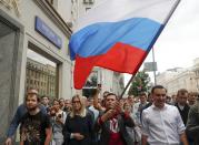 Russian opposition candidate Ilya Yashin, center right, and opposition candidate and lawyer at the Foundation for Fighting Corruption Lyubov Sobol, center left, walk during a protest in Moscow, Russia, Sunday, July 14, 2019. Opposition candidates who run for seats in the city legislature in September's elections have complained that authorities try to bar them from the race by questioning the validity of signatures of city residents they must collect in order to qualify for the race. (AP Photo/Pavel Golovkin)