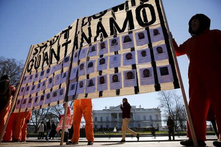 Protesters in orange jumpsuits from Amnesty International USA and other organizations rally outside the White House to demand the closure of the U.S. prison at Guantanamo Bay, in Washington January 11, 2016. REUTERS/Jonathan Ernst,