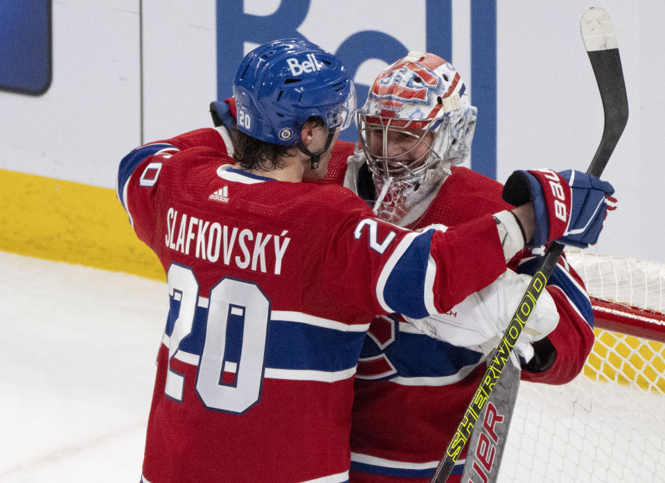 Montreal Canadiens goaltender Cayden Primeau (30) is congratulated on the team's win against the Columbus Blue Jackets by teammate Juraj Slafkovsky (20), after NHL hockey game Tuesday, March 12, 2024, in Montreal. (Christinne Muschi/The Canadian Press via AP)