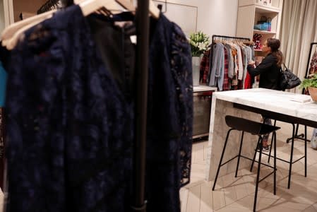 A woman looks at clothes at the Rent The Runway store, an online subscription service for women to rent designer dress and accessory items, in New York City