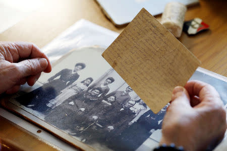 Holocaust survivor Betty Kazin Rosenbaum, 76, holds an old letter and a family photo during an interview in her house in Zichron Yaakov, Israel, April 10, 2018. Picture taken April 10, 2018. REUTERS/Nir Elias