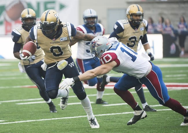 Winnipeg Blue Bombers' Johnny Sears, left, is tackled by Montreal Alouettes' Marc-Olivier Brouillette during first half CFL football action in Montreal, Monday, October 14, 2013. THE CANADIAN PRESS/Graham Hughes