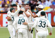 Australia's Josh Hazlewood, centre, is congratulated by teammates after dismissing India's Mayank Agarwal during play on day three of the fourth cricket test between India and Australia at the Gabba, Brisbane, Australia, Sunday, Jan. 17, 2021. (AP Photo/Tertius Pickard))