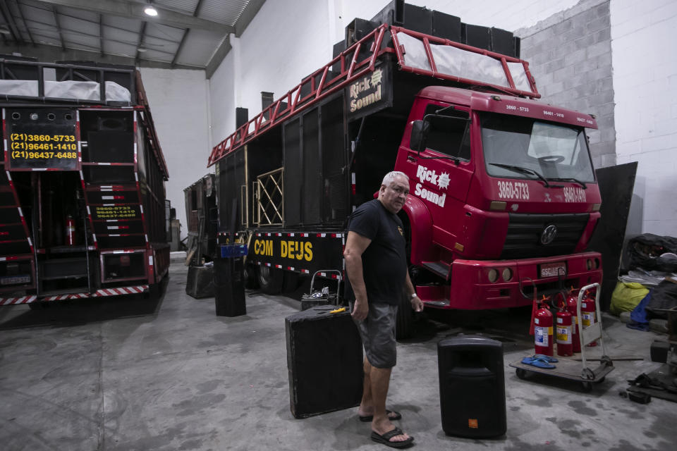 Rick Mello walks through his company warehouse, in Rio de Janeiro, Brazil, Tuesday, Jan. 30, 2024. Mello's Rick Sound company provides electric trios for more than two dozen street parties in Rio and also rents the sound trucks to samba schools rehearsing for the traditional Sambadrome parade. (AP Photo/Bruna Prado)