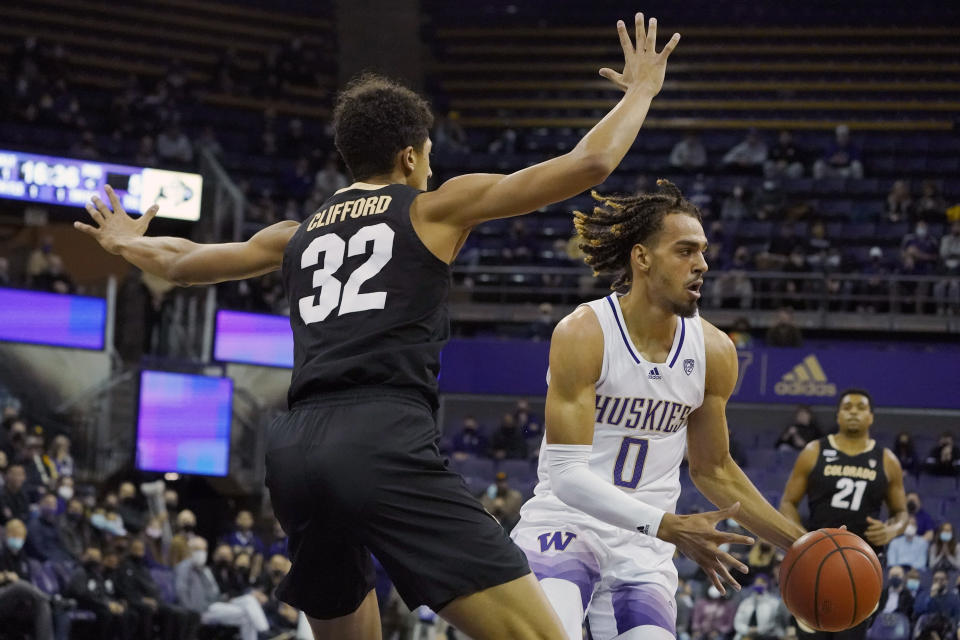 Washington forward Emmitt Matthews Jr. (0) looks to pass around Colorado guard Nique Clifford (32) during the first half of an NCAA college basketball game, Thursday, Jan. 27, 2022, in Seattle. (AP Photo/Ted S. Warren)