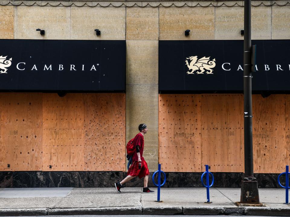 A man walks past a boarded business center near the Hennepin County Government Center in Minneapolis, Minnesota on 18 April, 2021AFP via Getty Images