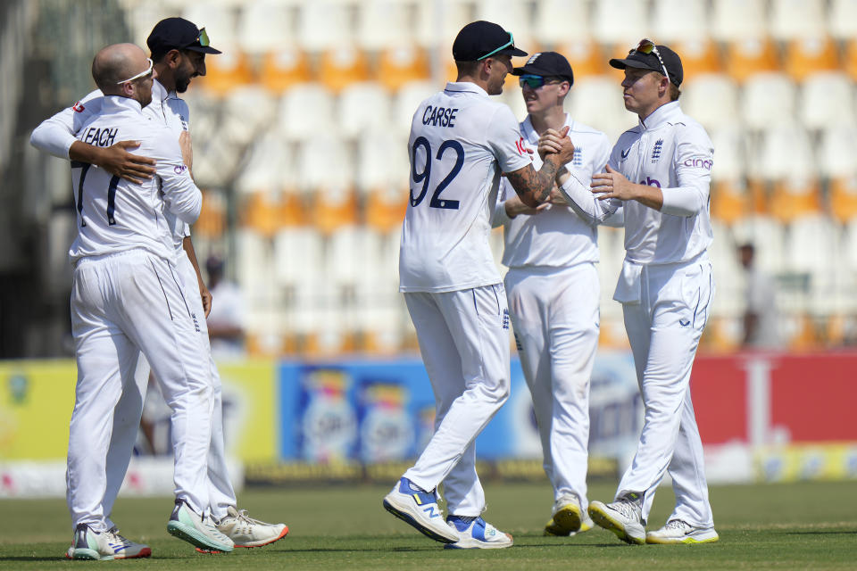 England's Ollie Pope, left, and teammates are congratulated each others after winning the first test cricket match against Pakistan, in Multan, Pakistan, Friday, Oct. 11, 2024. (AP Photo/Anjum Naveed)