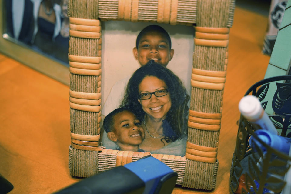 A photo of Alton Lucas' wife, Bronwyn Lucas, and their children, sits on a desk at his home outside of Raleigh, N.C., on Friday, June 18, 2021. His wife, whom he’d met at a fatherhood counseling conference, said his past had barred him from doing something as innocuous as chaperoning their children on school field trips. (AP Photo/Allen G. Breed)