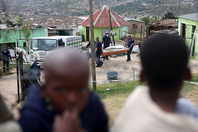 A body is moved at the scene of a deadly mass shooting, near Pietermaritzburg