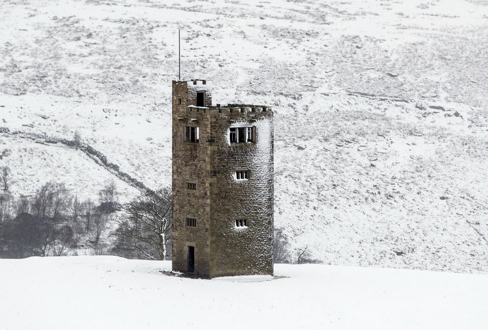 Snow surrounds Boots Folly in the Peak District, England, Sunday Feb. 7, 2021, with bitterly cold winds and heavy snow set to bring disruption to some parts of England. (Danny Lawson/PA via AP)