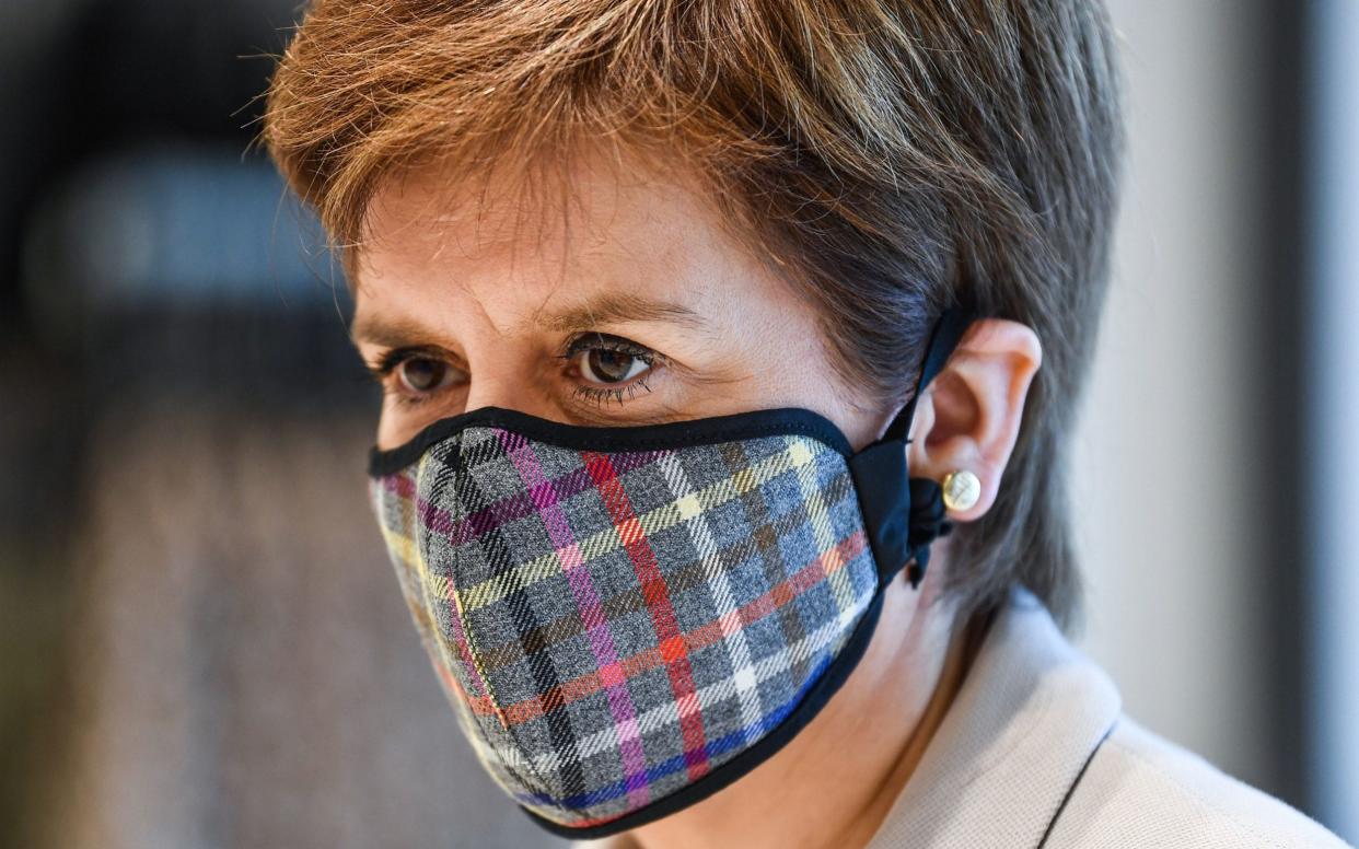 First Minister Nicola Sturgeon, wearing a Tartan face mask during a visit to New Look at Ford Kinaird Retail Park in Edinburgh - PA