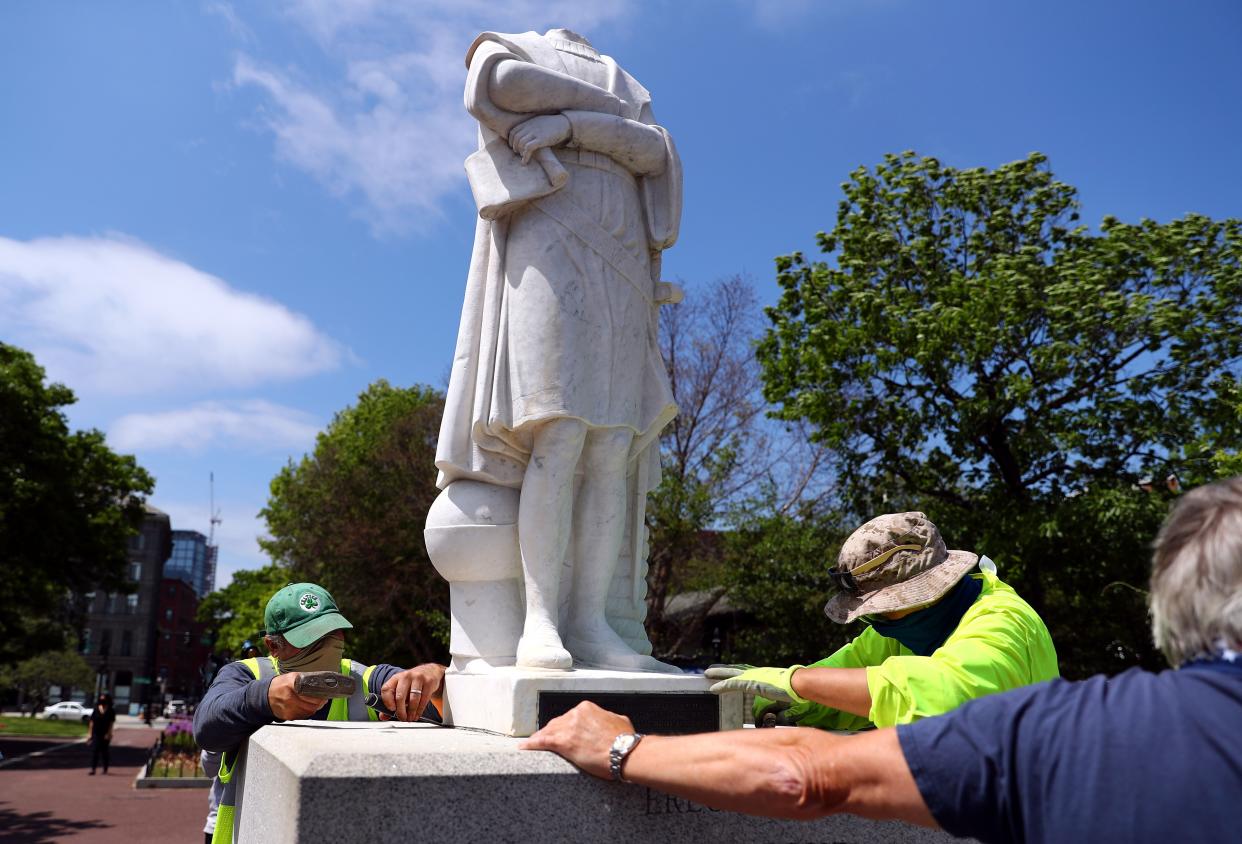 Workers from Daedalus Inc. attempt to remove a statue depicting Christopher Columbus, which had its head removed, at Christopher Columbus Waterfront Park on June 10, 2020 in Boston, Mass. The statue was beheaded overnight and is scheduled to be removed by the City of Boston.